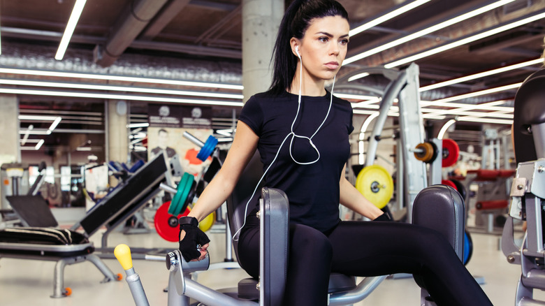 woman using hip abductor machine