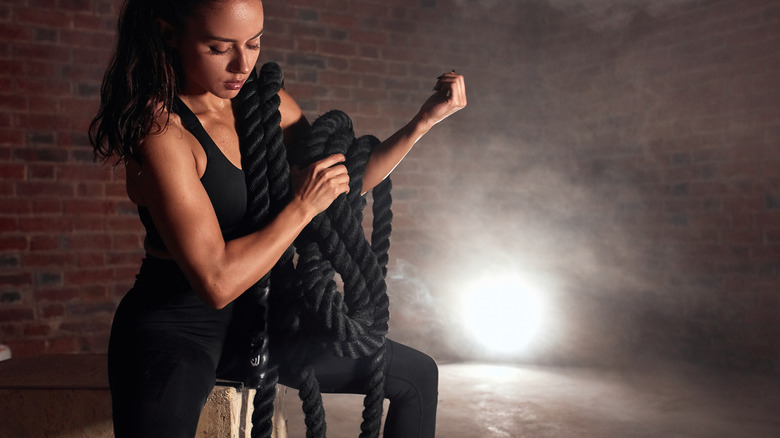 woman sitting with battle ropes