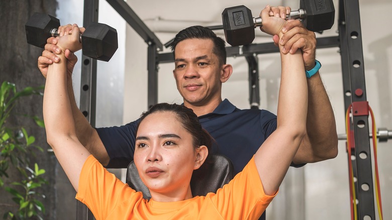 woman lifting weights while seated