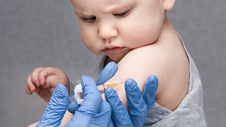 Young baby receiving vaccine in upper arm