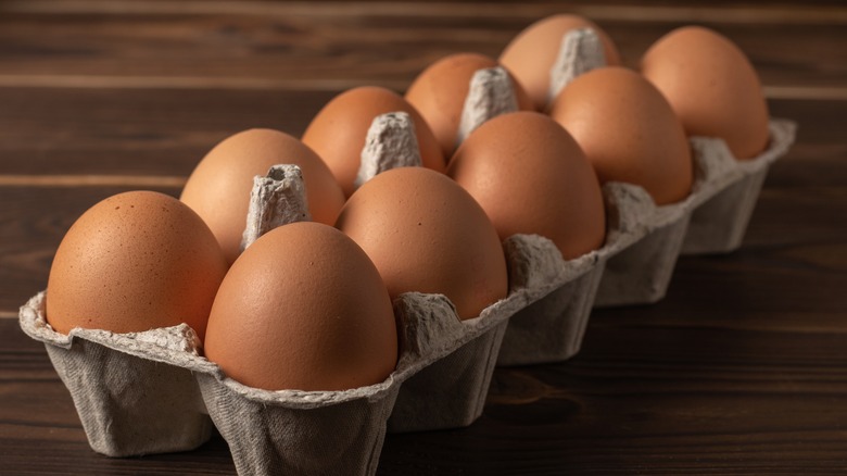 Carton of ten eggs on a wooden surface