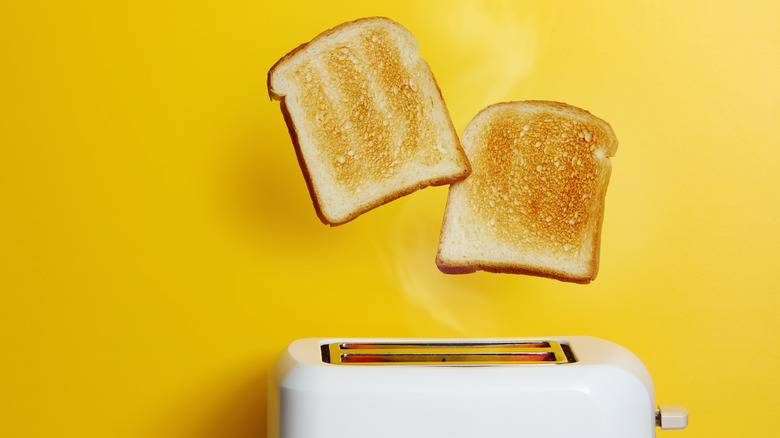 Pieces of bread popping out of a toaster
