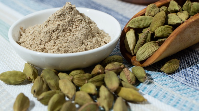 Cardamom next to cardamom powder