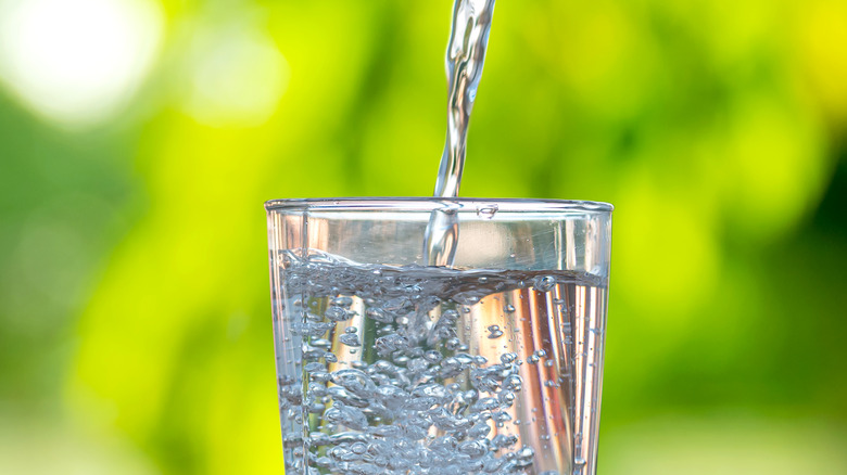 Glass of water being poured outside