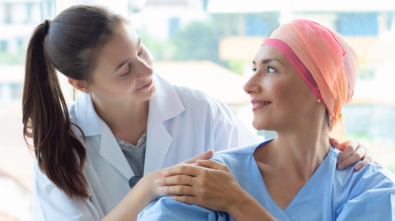 A medical professional comforting a cancer patient 