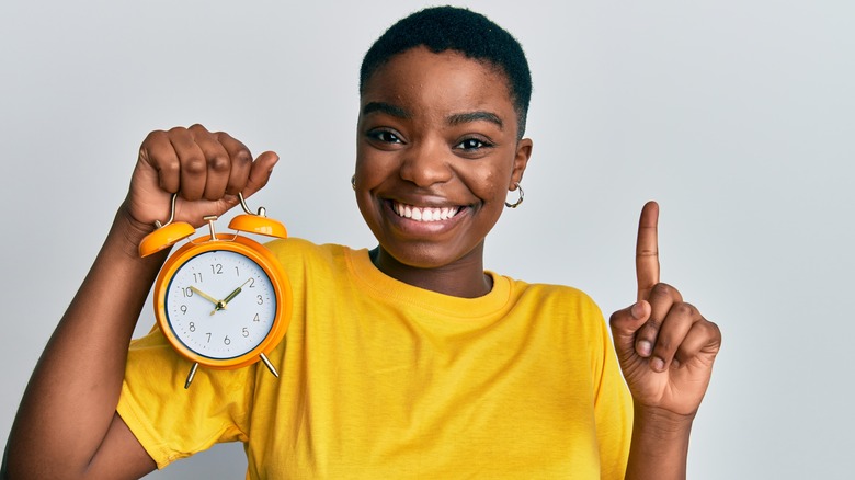 happy fit girl with clock