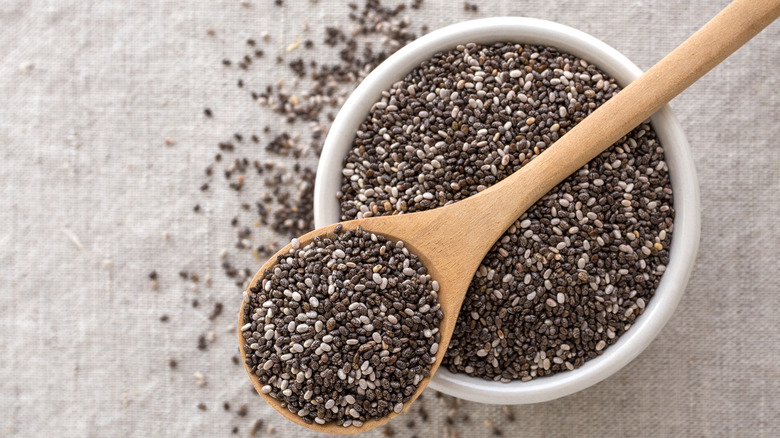 Overhead shot of a bowl and a wooden spoon filled with chia seeds