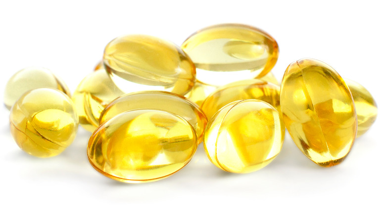 Close up of a pile of fish oil supplements against a white background