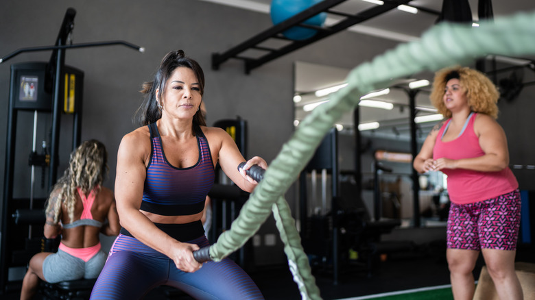 woman using battle ropes in the gym