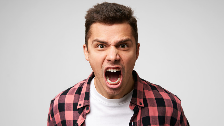 angry man screaming against white background
