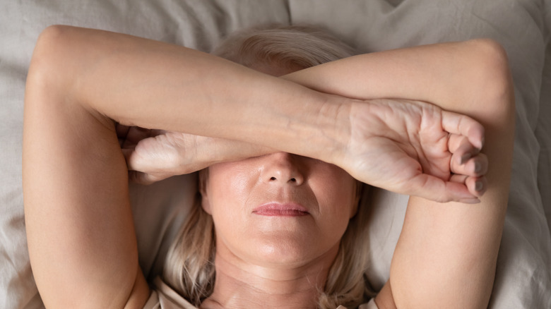 woman with insomnia covering eyes