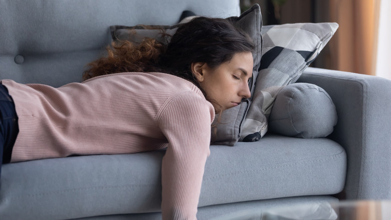 exhausted woman lying down on sofa
