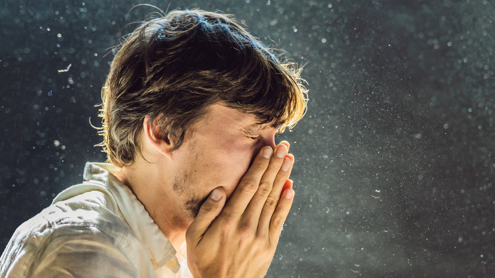 Man having allergies to dust in the air