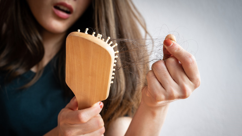 woman removing hair from brush 