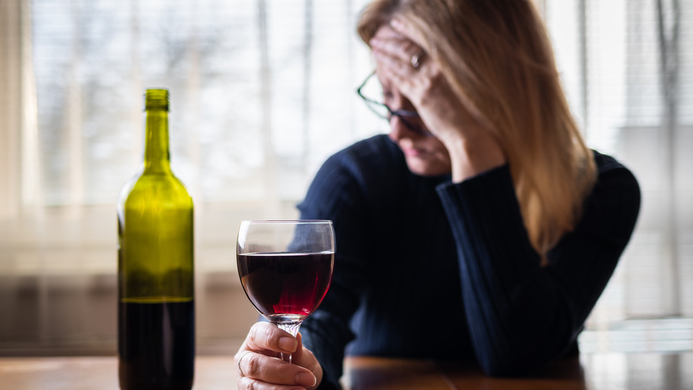 ashamed woman holding wine glass