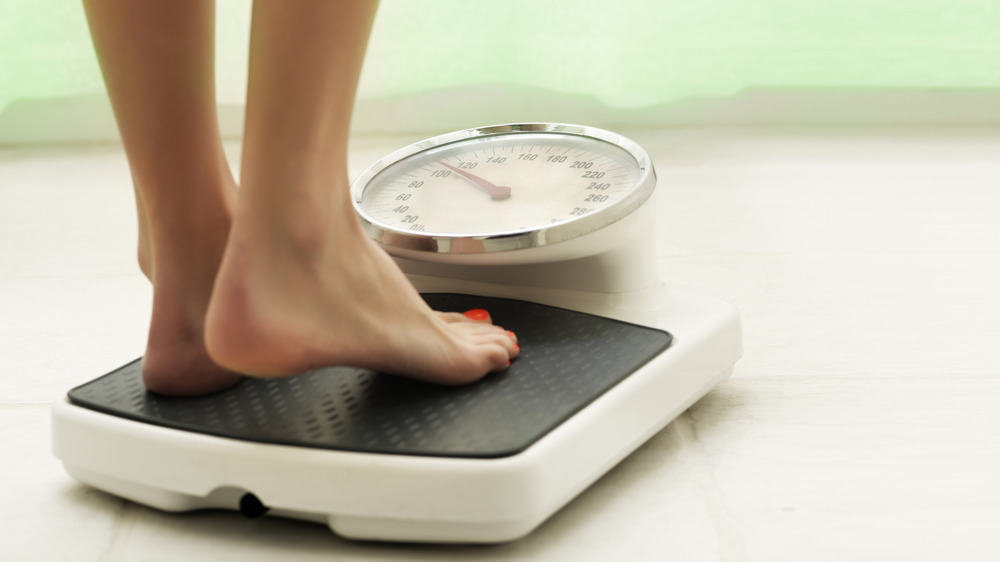 woman weighing self