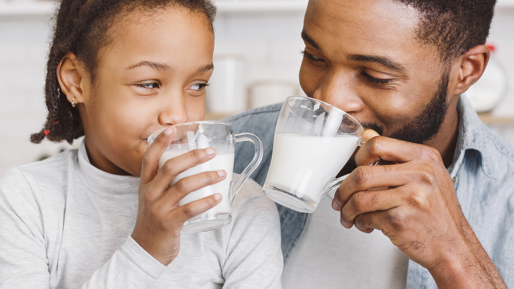 father and daughter drinking milk