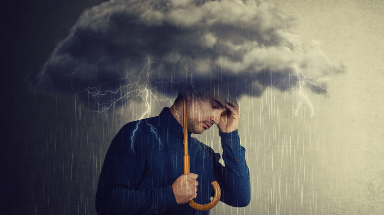 man holding raincloud umbrella