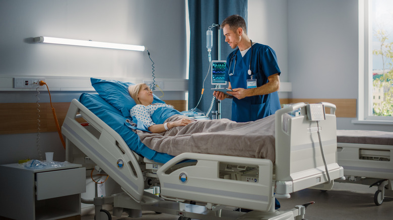 A doctor speaks to a woman after surgery