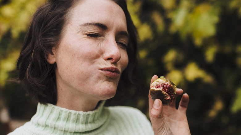 woman happily eating dried fig