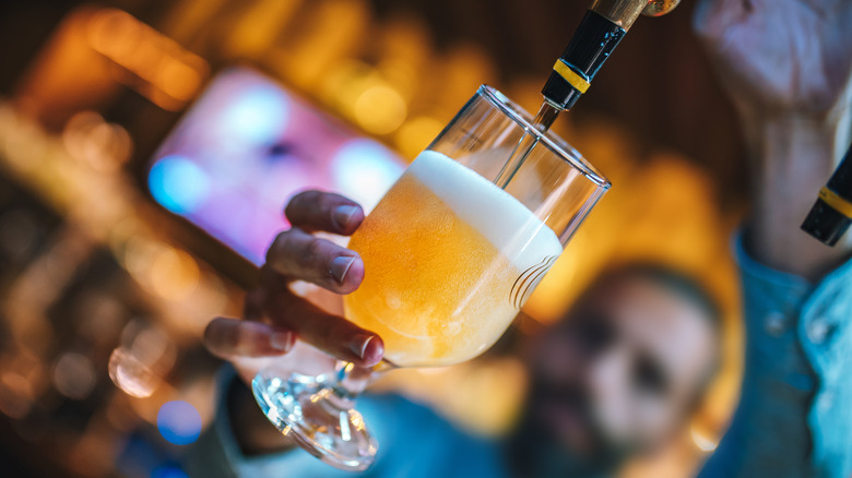 bartender pouring beer from a tap 