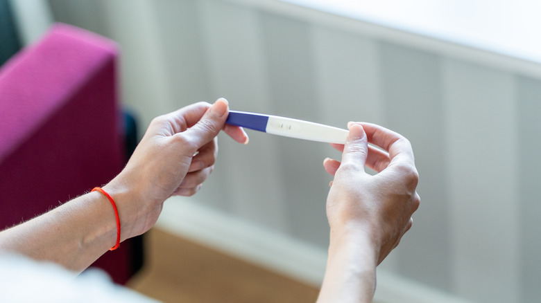 Woman holding pregnancy test