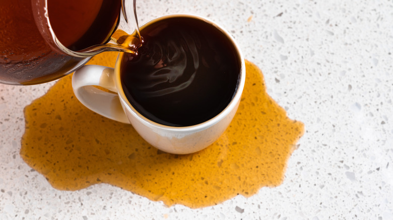 Over view of coffee being poured into a glass in excess