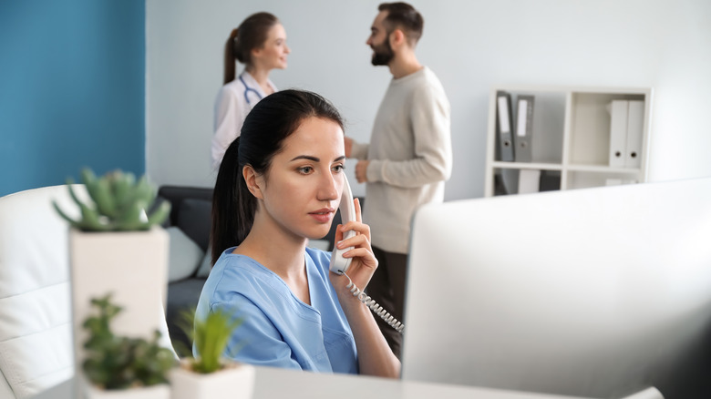 receptionist talking on phone at doctor's office