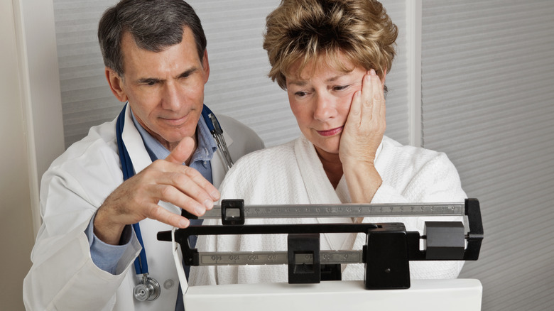 doctor weighing patient