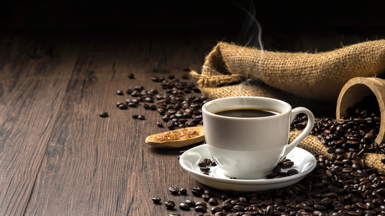 cup of hot coffee with coffee beans