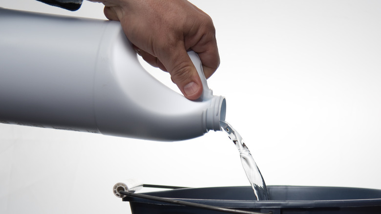 pouring bleach in a bucket