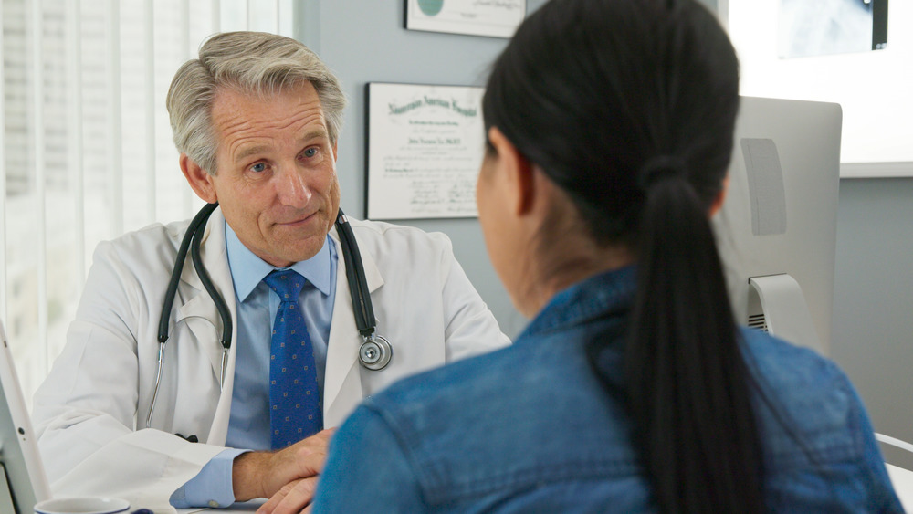 white male doctor talking to patient