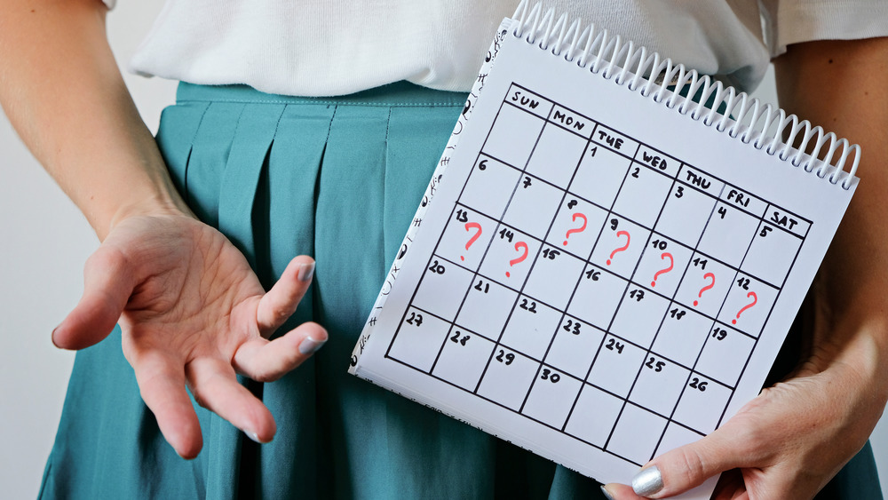 woman holding calendar of missed period days
