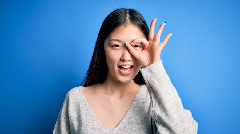 woman looking through fingers