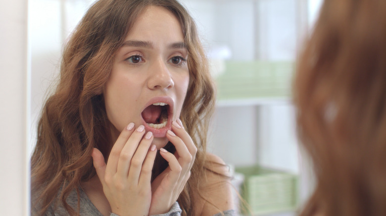 Young woman examining her mouth