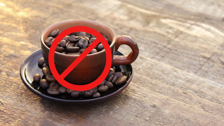 Crossed out coffee cup with coffee beans, no coffee allowed