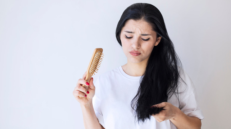 A woman brushes dry hair