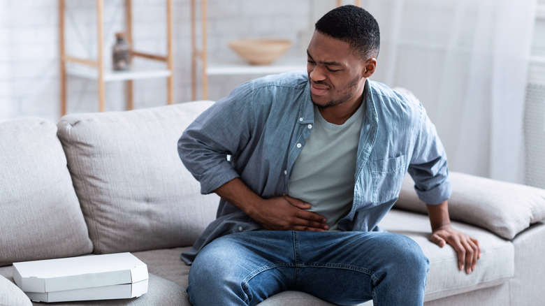 Man holding stomach in pain after eating spicy food