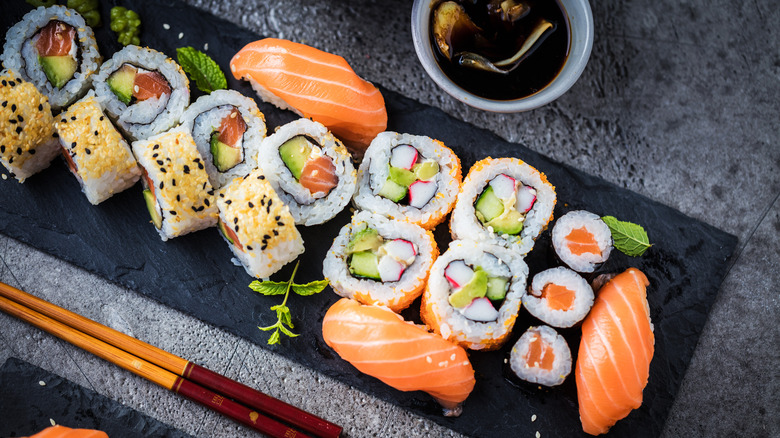 Sushi rolls on a black serving board