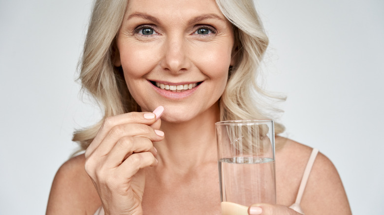 A woman takes a probiotic supplement