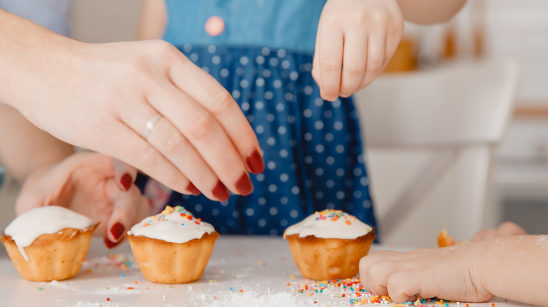 children and parent decorating cupcakes
