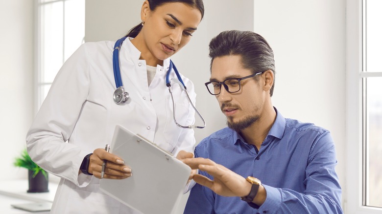 man reading from doctor's clipboard