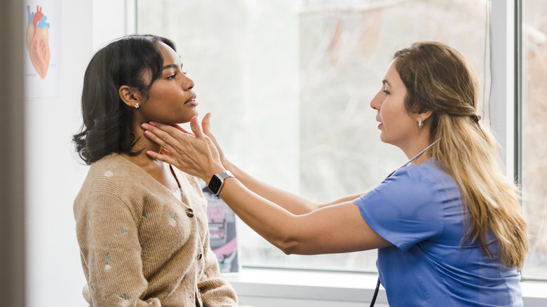 doctor examining patient's neck