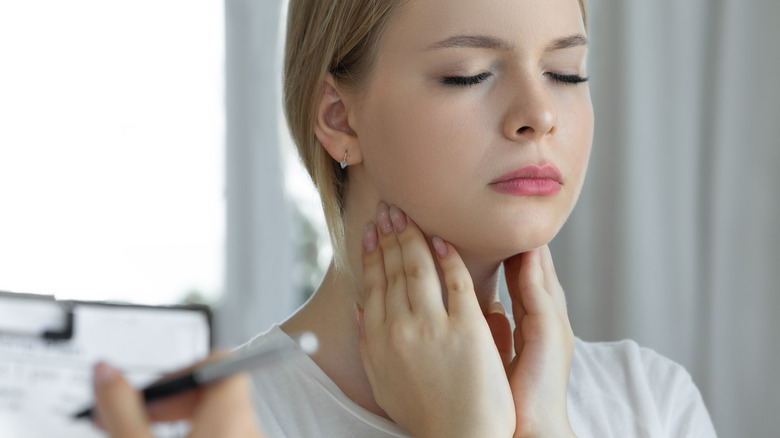 woman feeling swollen neck glands