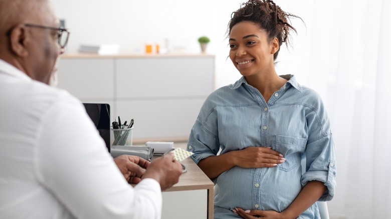 doctor talking with pregnant person