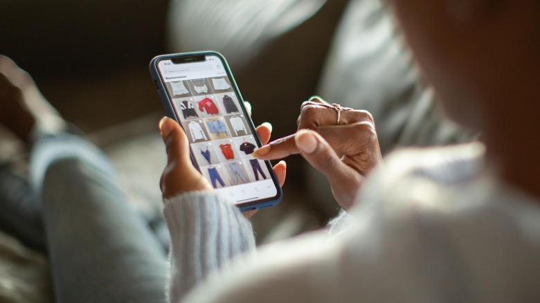 woman's hand scrolling through shopping site on phone