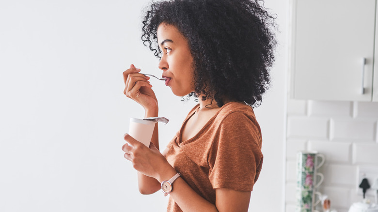 woman eating a tub of yogurt