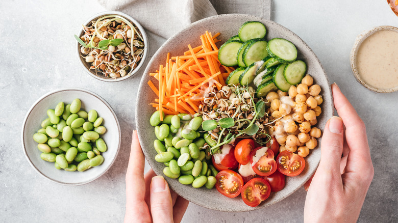 Buddha bowl with chickpeas, edamame, tomatoes, and carrots