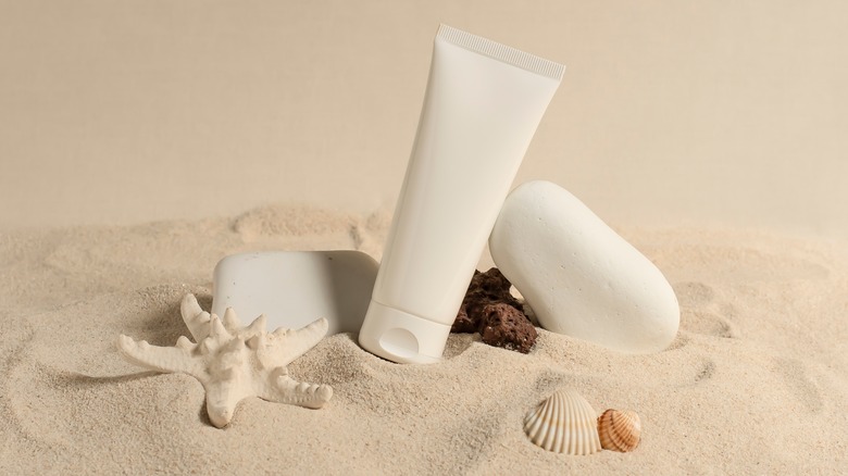 sun lotion bottle in sand