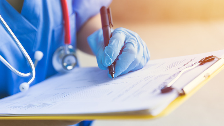 Nurse filling medical chart